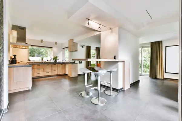 A spacious, modern kitchen featuring large grey slip-resistant floor tiles that provide comfort and safety