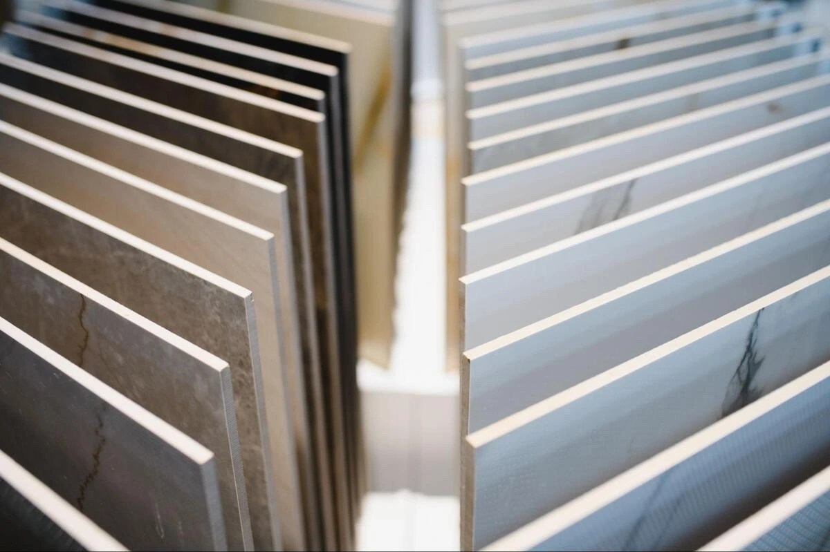 Rows of large ceramic tile samples displayed vertically on racks in a tile showroom